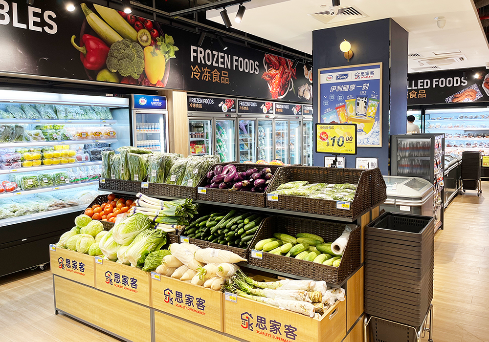 A vibrant supermarket aisle showcasing fresh produce, frozen foods, and chilled items.
