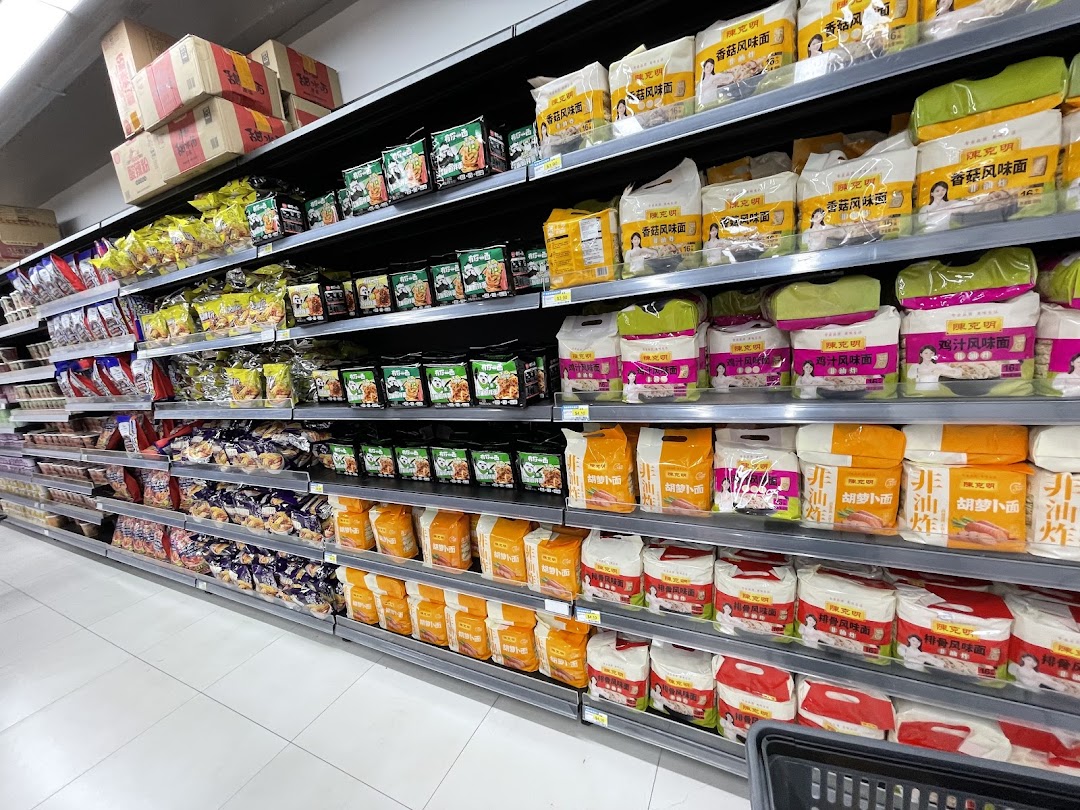 An aisle in Scarlett Supermarket showcasing shelves stocked with various packaged Asian food products, including instant noodles.