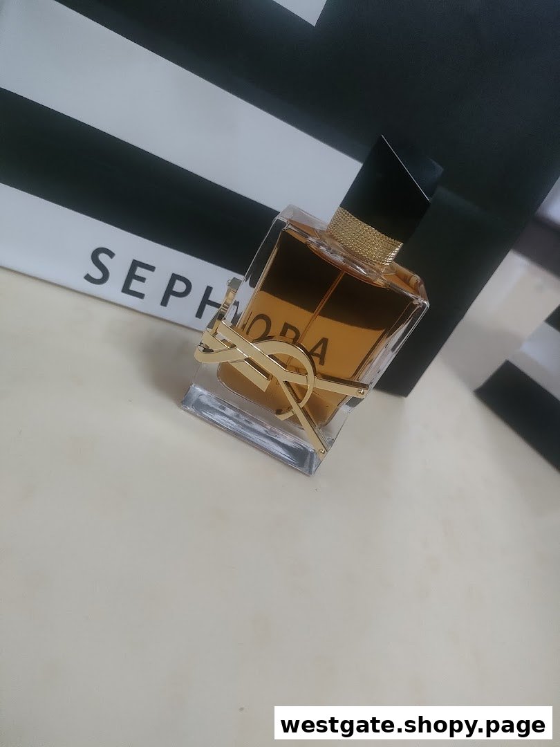 A YSL Libre perfume bottle sits in front of a Sephora shopping bag.