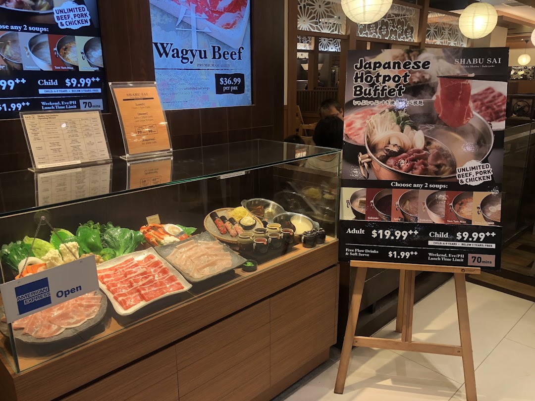 A vibrant display of fresh ingredients and promotional signs for Shabu Sai's Japanese hotpot buffet.