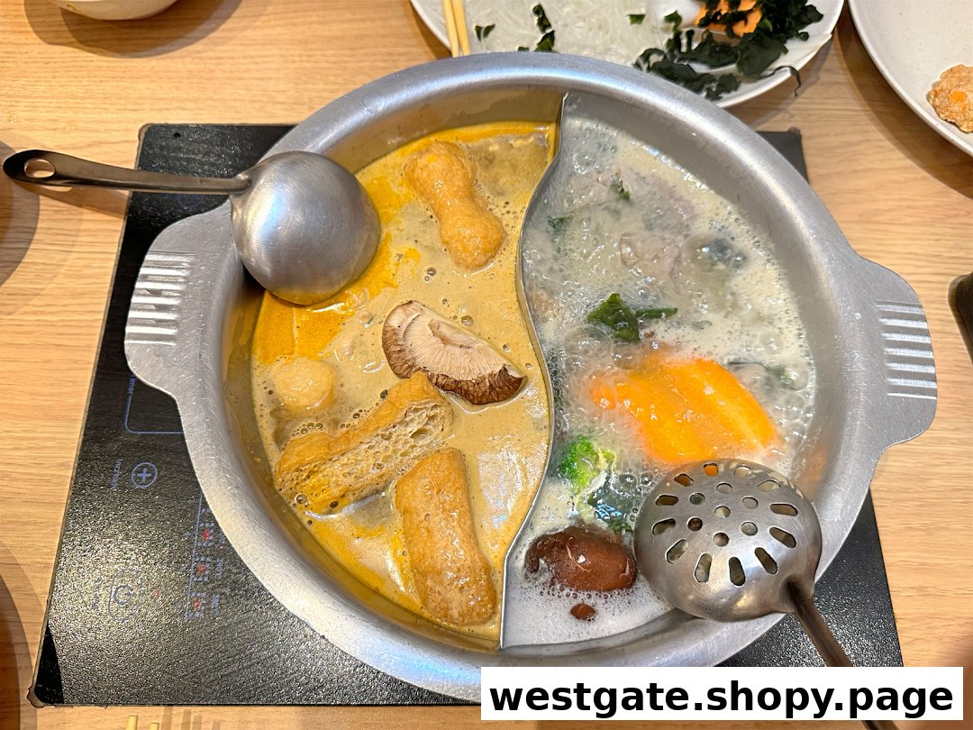 A bubbling hot pot with two distinct broths and various ingredients cooking on a tabletop induction cooker.