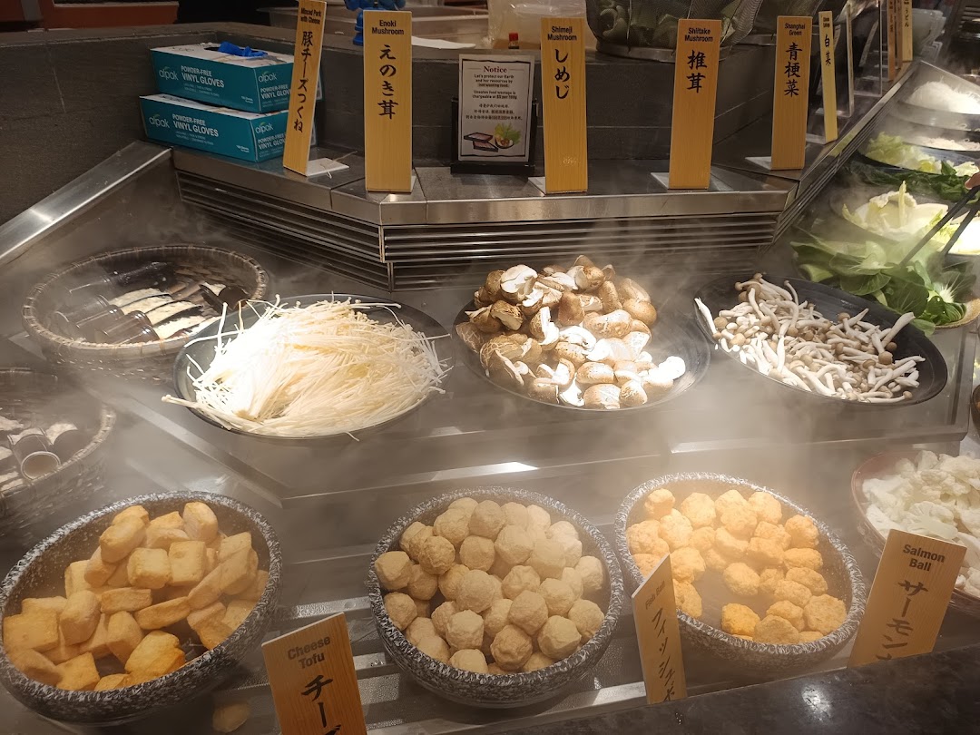 A vibrant display of fresh ingredients like mushrooms, tofu, and various balls for a hot pot buffet.