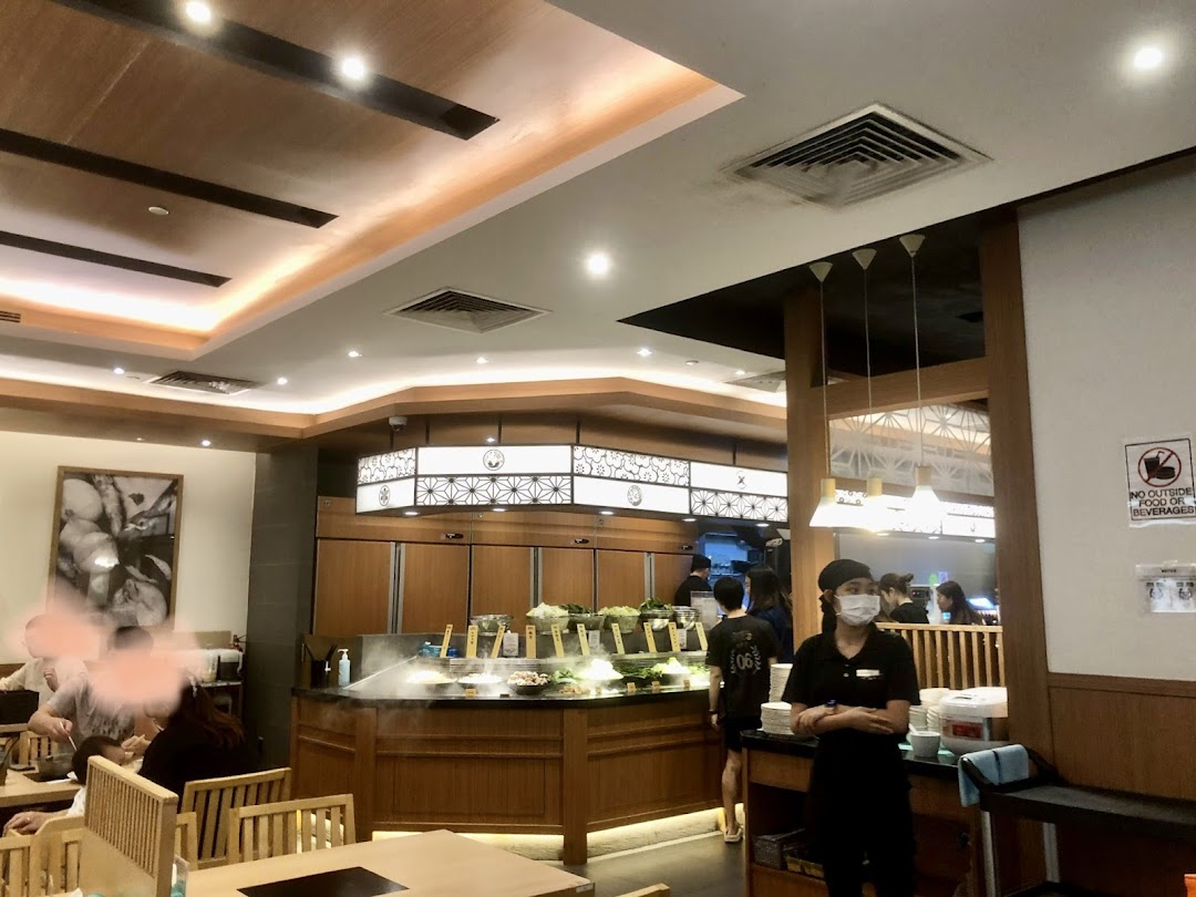 Interior view of Shabu Sai, showing a fresh buffet line, dining area, and staff.