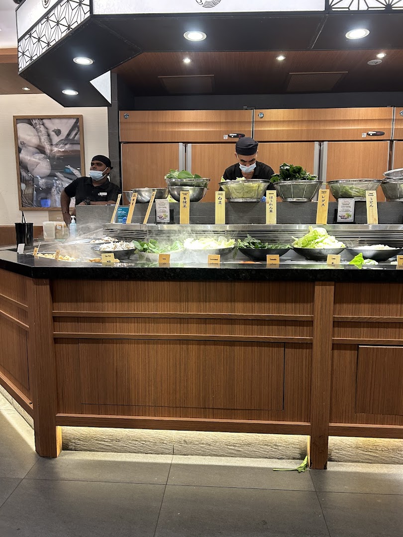 Staff prepare fresh ingredients at Shabu Sai's vibrant hot pot buffet counter.