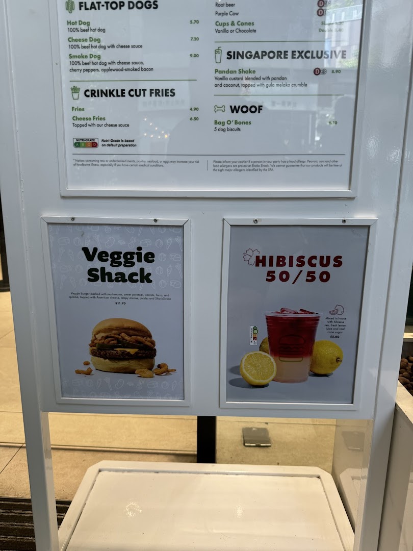 A detailed menu board displaying various food and drink items, including hot dogs, fries, shakes, and a veggie burger.