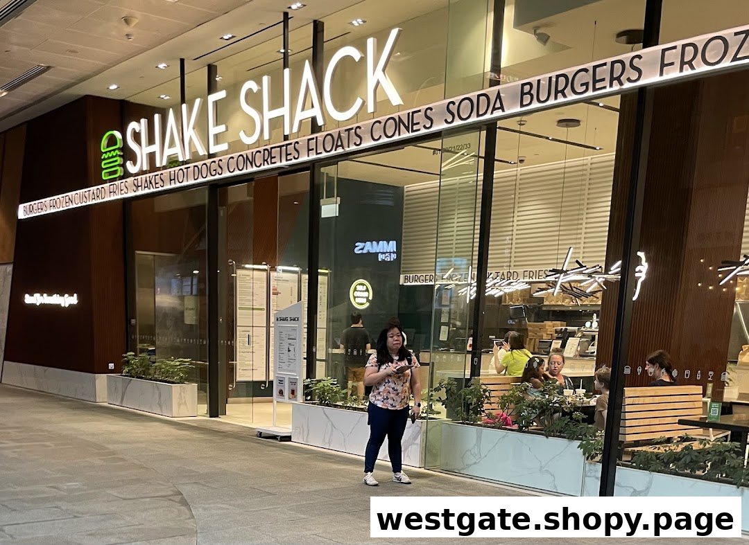 The illuminated storefront of Shake Shack, showcasing its entrance and product offerings.