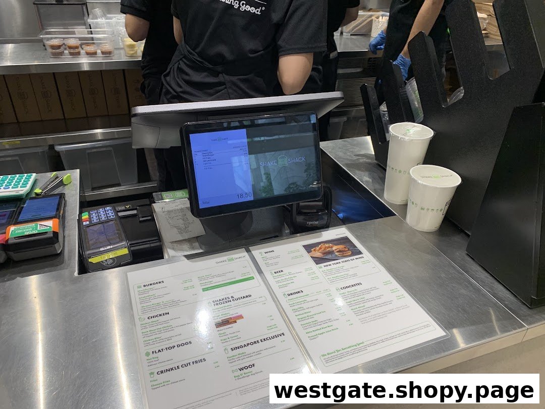 A close-up of the Shake Shack counter with a digital display, payment terminal, and physical menu.