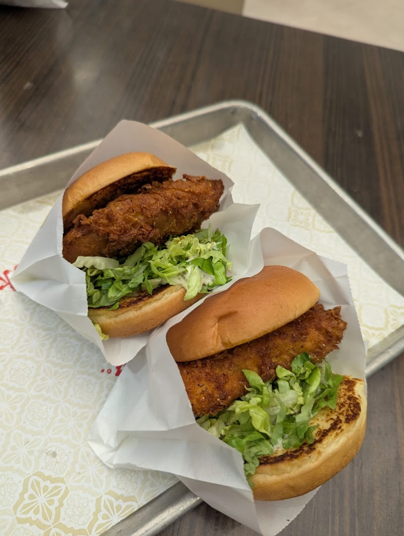 Two crispy fried chicken sandwiches with lettuce on a tray.