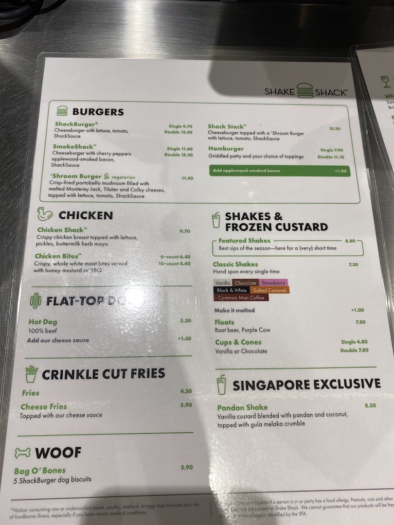 A detailed menu board displaying Shake Shack's burgers, chicken, fries, shakes, and exclusive items.