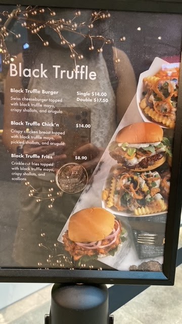 A menu board displaying Shake Shack's Black Truffle offerings with prices and images.