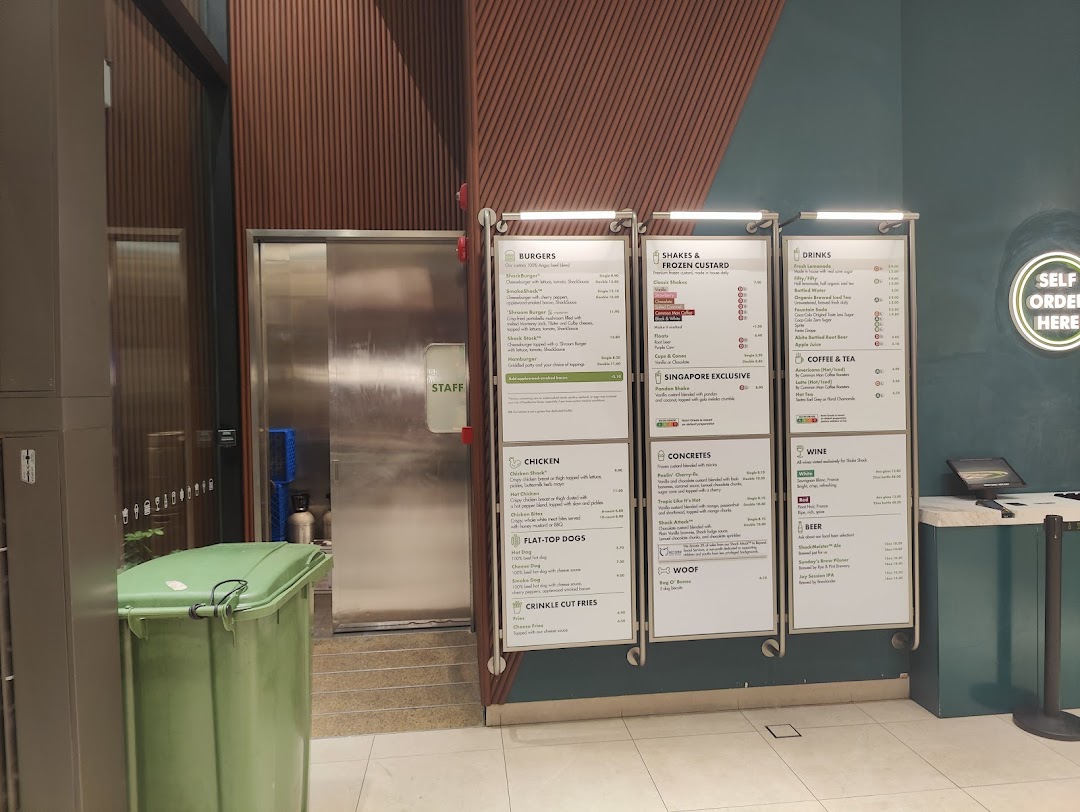 The ordering area of Shake Shack Westgate, featuring prominent menu boards and a 'Self Order Here' sign.
