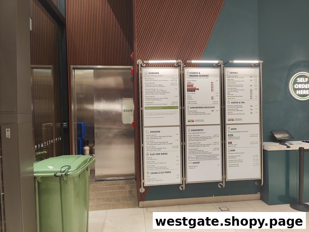 The ordering area of Shake Shack Westgate, featuring prominent menu boards and a 'Self Order Here' sign.