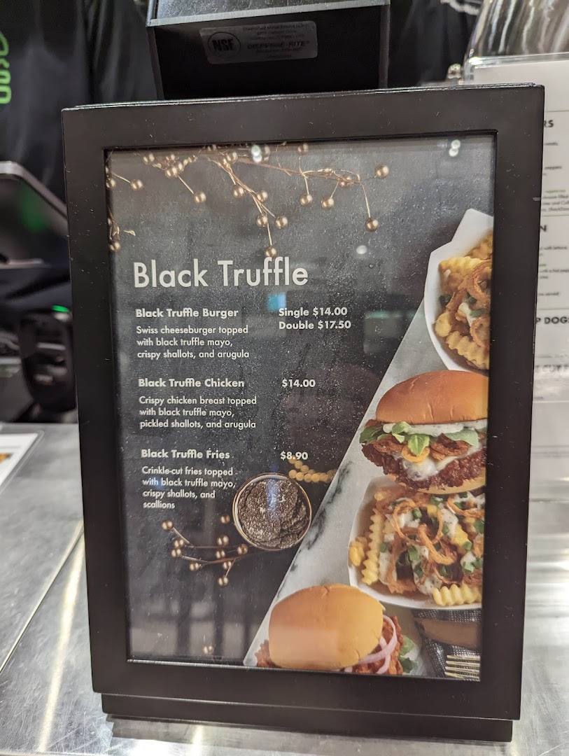 A close-up of Shake Shack's Black Truffle menu featuring burgers, chicken, and fries.