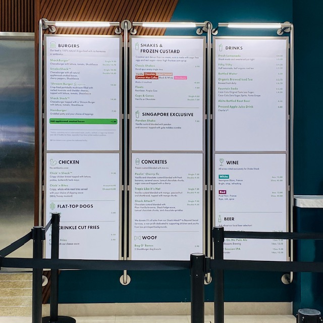A comprehensive menu board displaying food and drink options at Shake Shack Westgate.