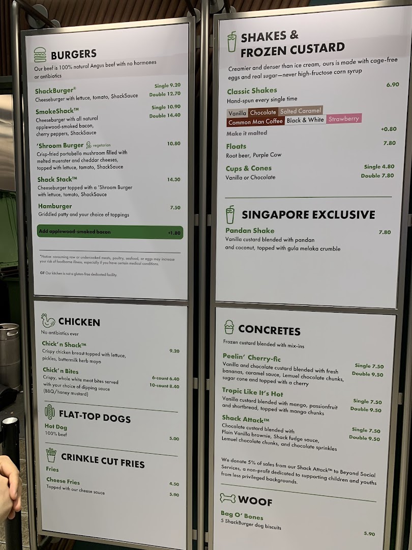 A detailed menu board displaying burgers, shakes, fries, and other items with prices.