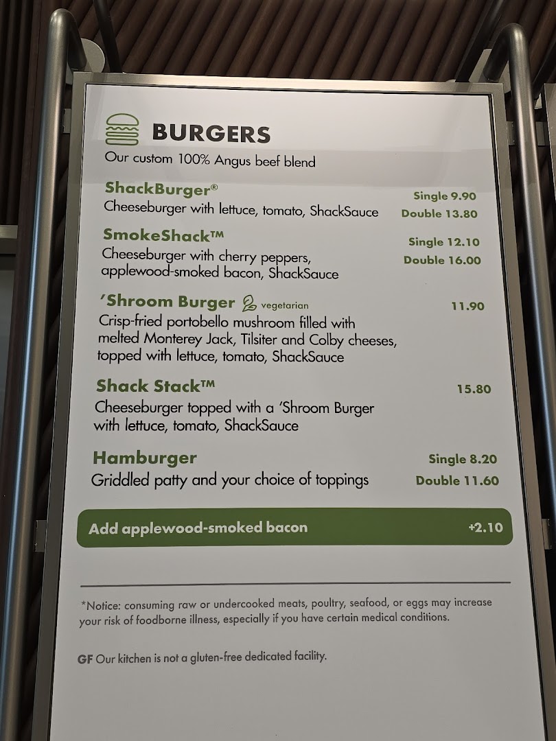 A close-up view of the Shake Shack menu board displaying various burger options and prices.