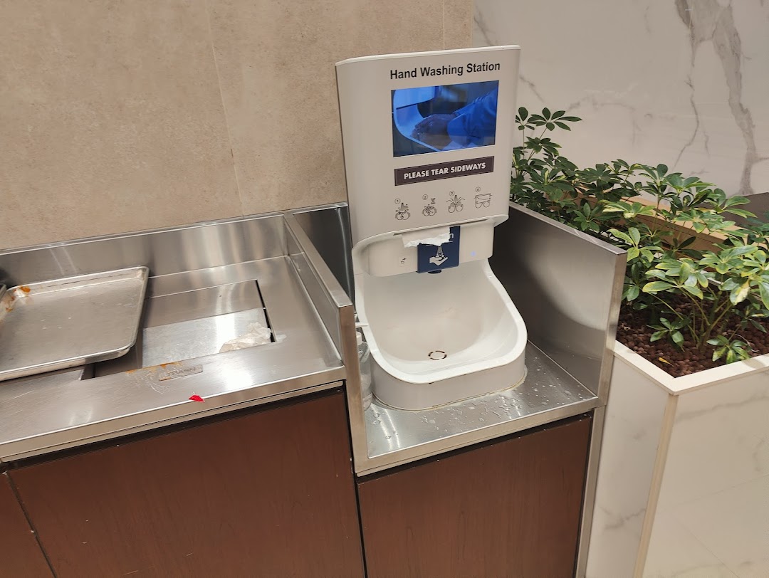 A hand washing station and tray disposal area inside Shake Shack, emphasizing cleanliness.