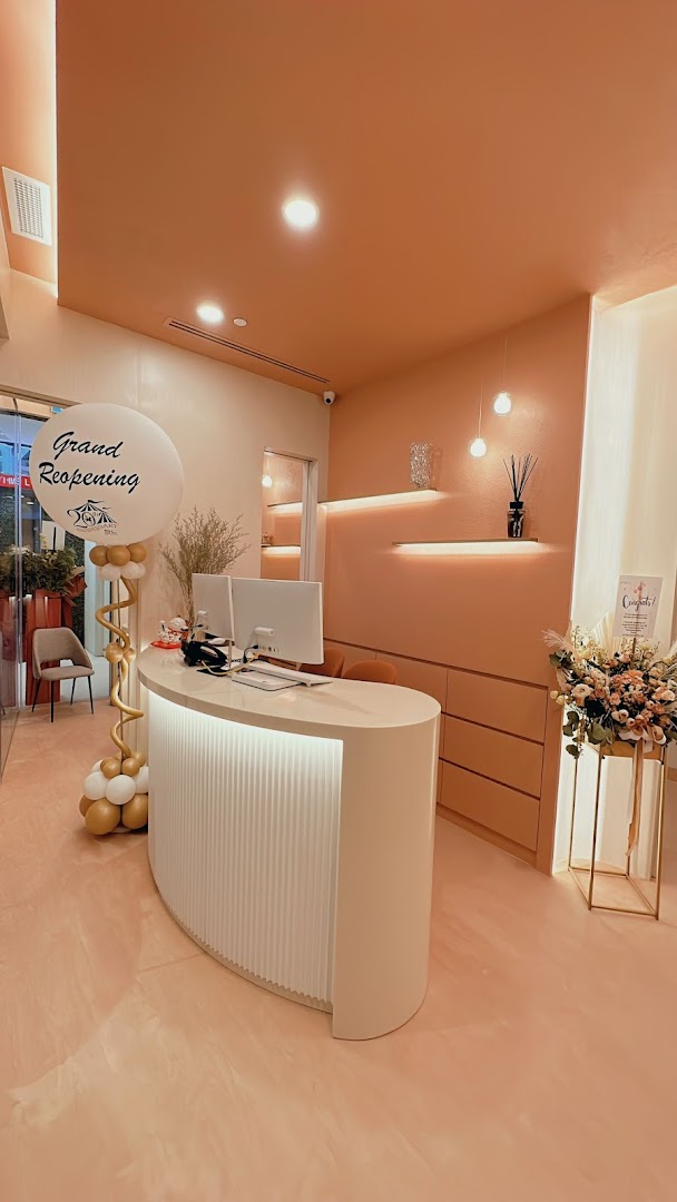 The image shows the modern, peach-toned reception area of SL Aesthetic Clinic, featuring a white desk and a 'Grand Reopening' balloon.