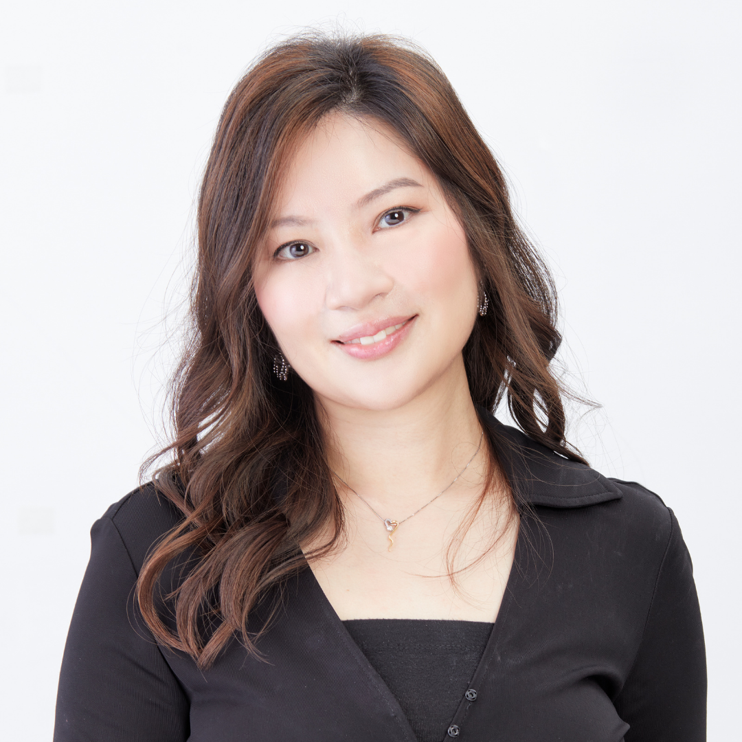 A smiling woman with long brown hair, wearing a black top, against a white background.