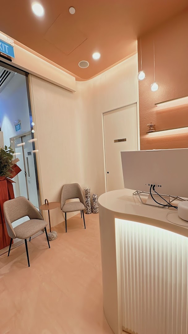 A modern and inviting reception area with a curved desk, comfortable seating, and warm lighting at SL Aesthetic Clinic.