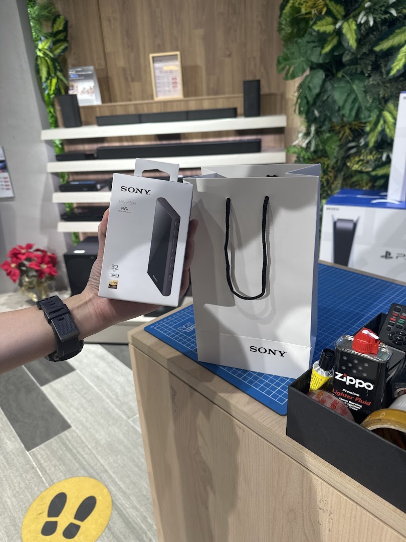 A customer holds a new Sony NW-A306 Walkman box next to a Sony shopping bag inside the store.