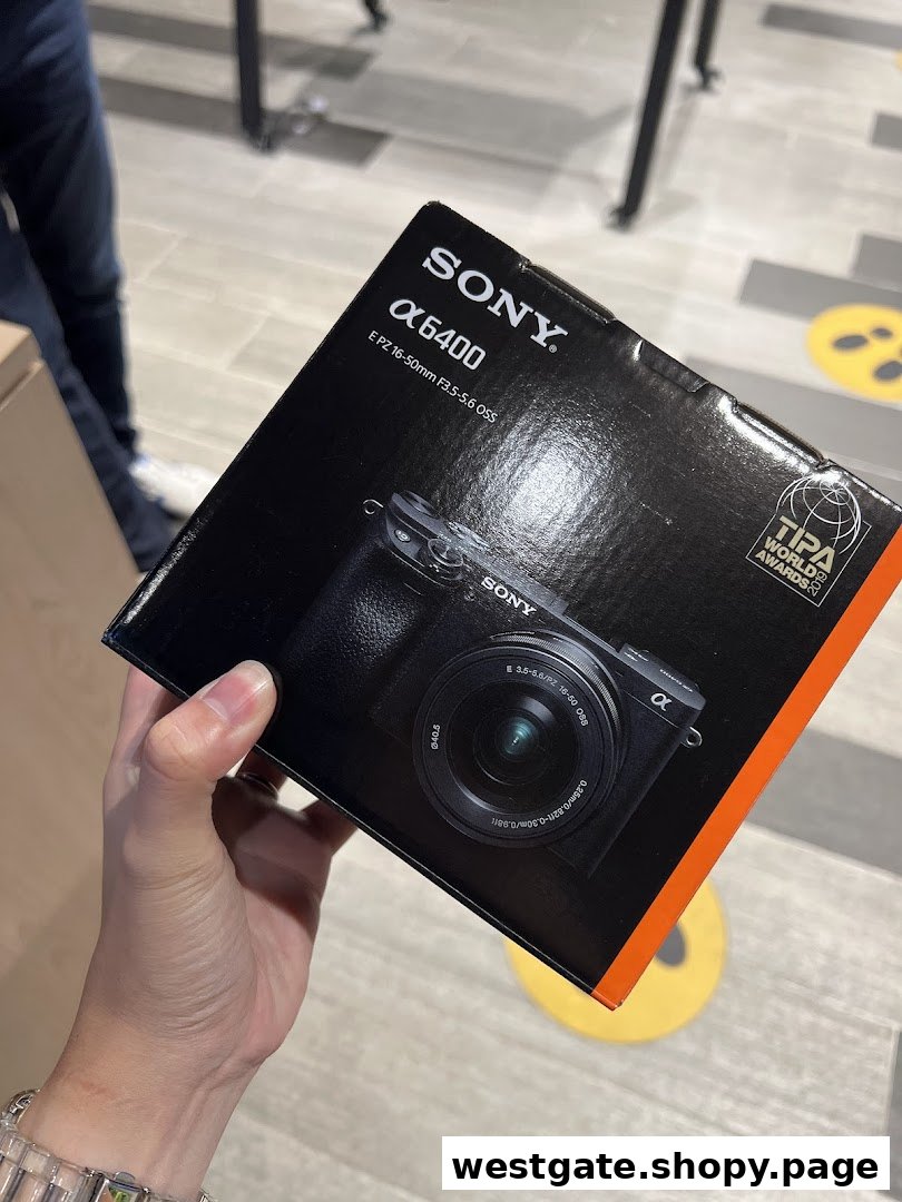 A hand holds a Sony Alpha 6400 camera box, showcasing the product in-store.