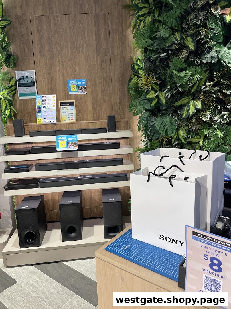 Sony soundbars and subwoofers displayed in a modern store setting with lush green wall decor.