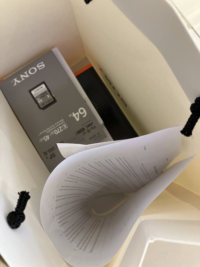 A Sony memory card and documents inside a shopping bag, representing a recent purchase.