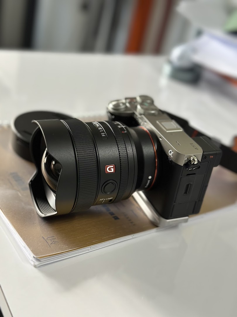 A close-up of a Sony mirrorless camera with a wide-angle lens on a desk.