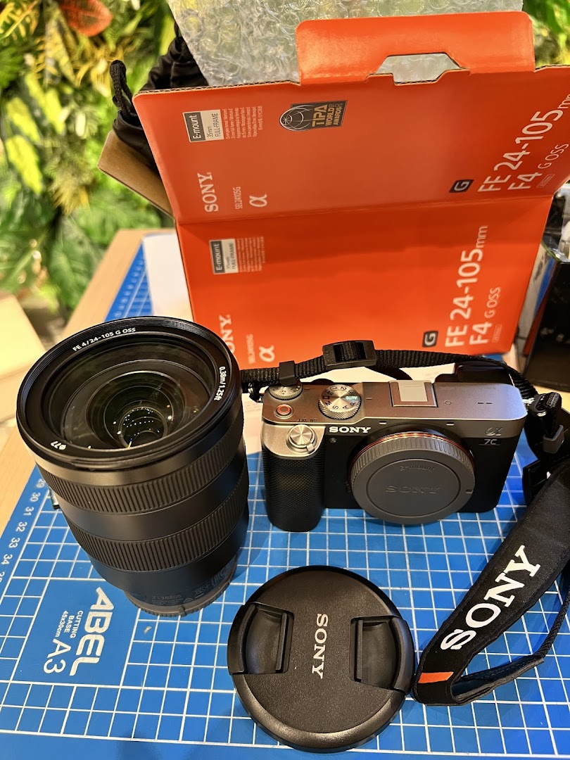 A new Sony Alpha camera, FE 24-105mm G OSS lens, and packaging are displayed on a cutting mat.