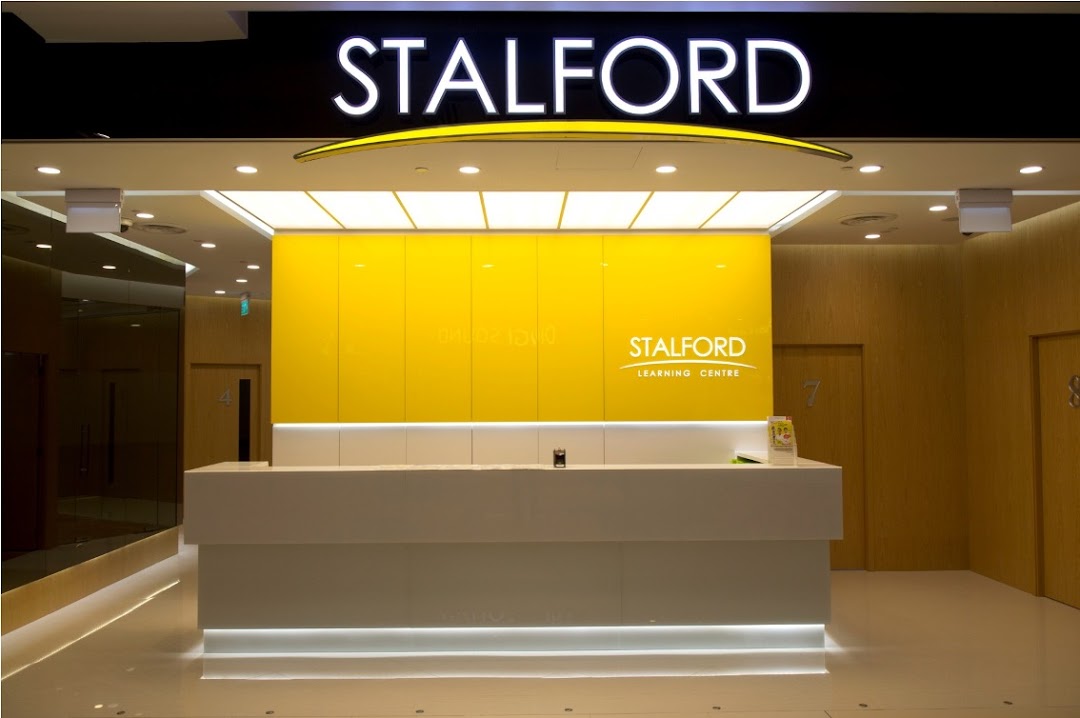 The bright and modern entrance of Stalford Learning Centre, featuring a reception desk and yellow accent wall.