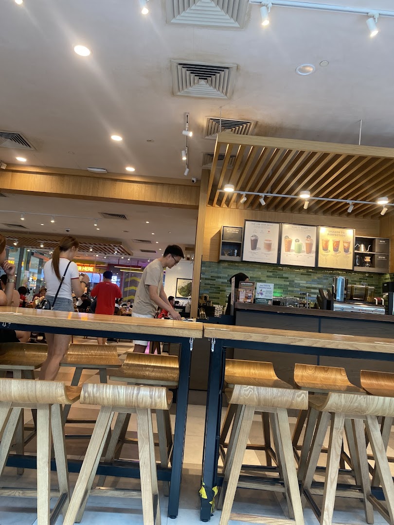 An interior view of Starbucks Westgate, showing customers, seating, and the service counter.