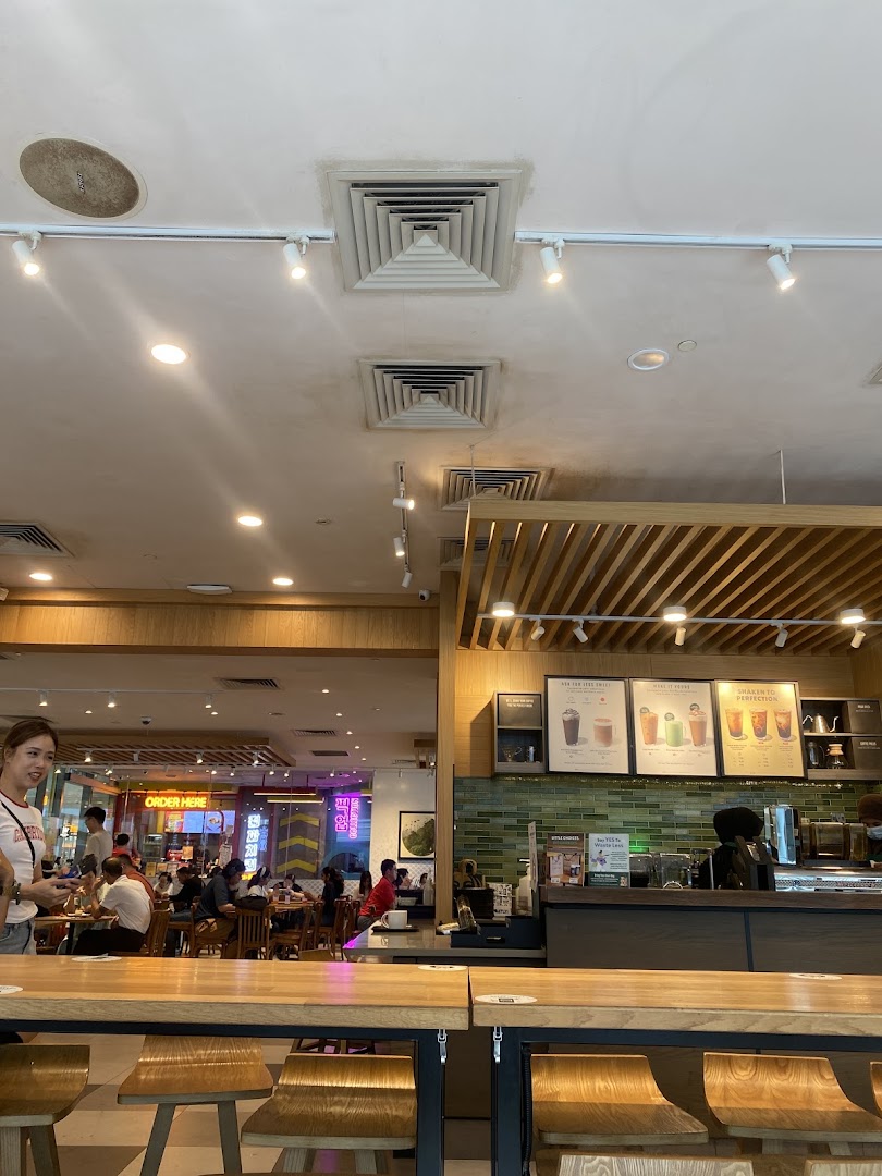 Interior view of Starbucks Westgate, showing the counter, seating area, and customers.