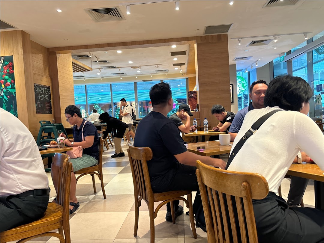 Customers enjoying coffee and conversation inside Starbucks Westgate, a bustling cafe environment.