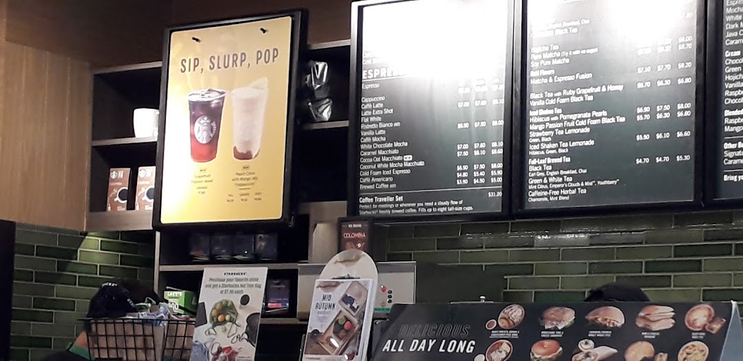 Starbucks menu boards displaying a variety of coffee, tea, and specialty beverages with prices.