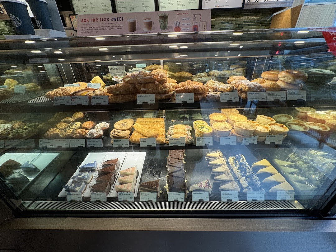 A vibrant display case showcasing a variety of fresh pastries, cakes, and savory bites at Starbucks.