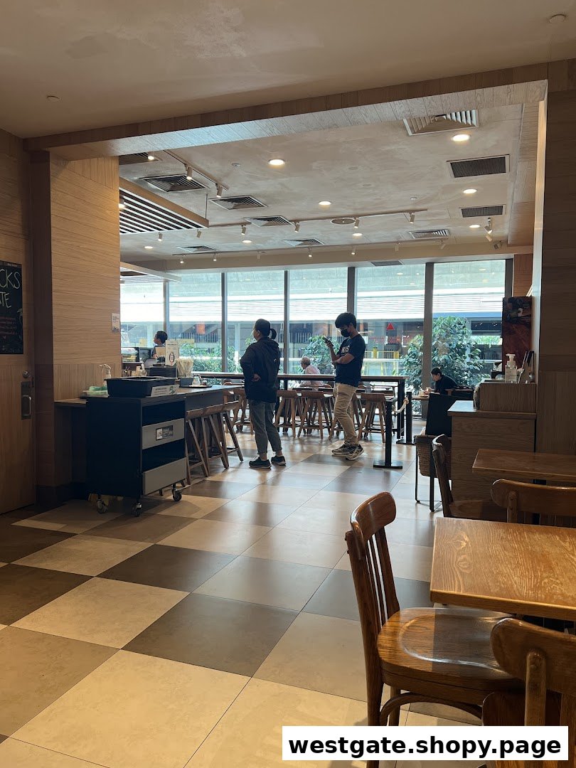 Interior view of Starbucks Westgate, showing customers, seating, and a bright window area.