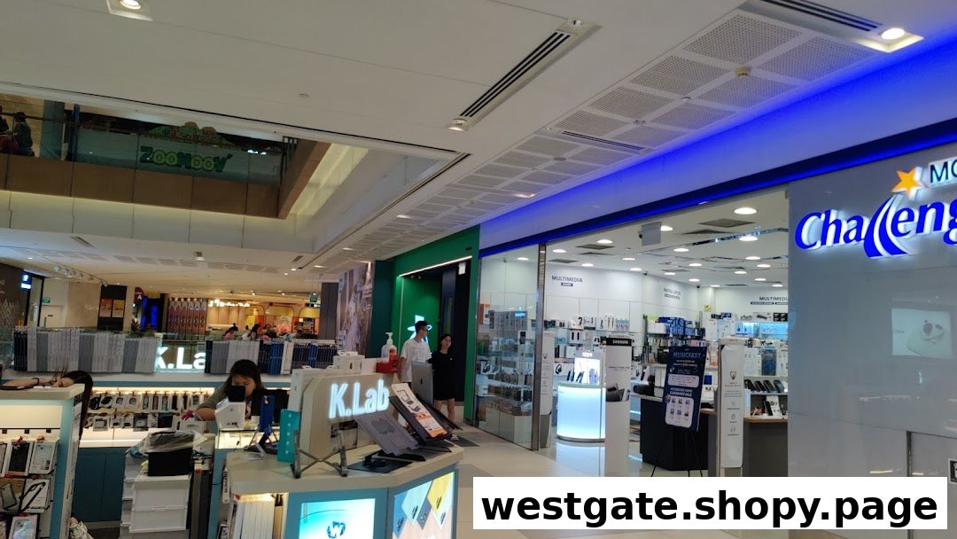 A bustling shopping mall interior featuring electronics stores and shoppers.