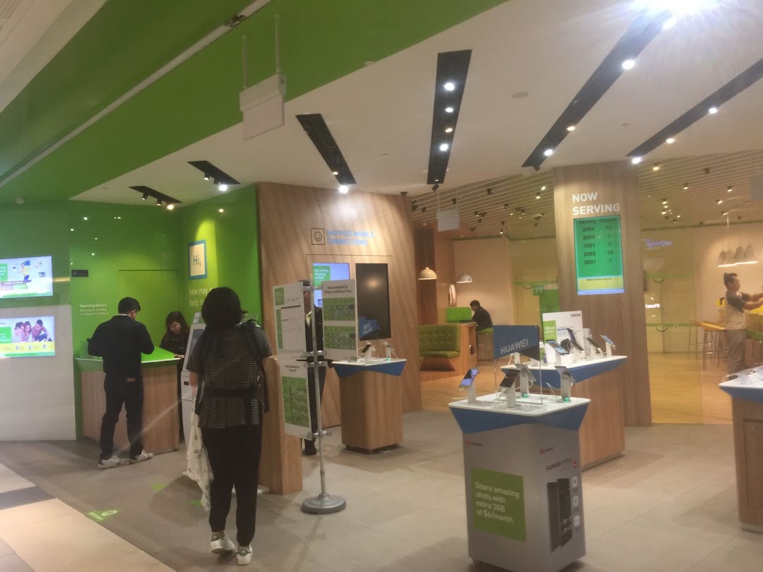 Interior view of StarHub Westgate, featuring customer service counters, mobile device displays, and customers.