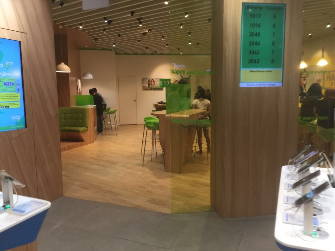 Interior view of StarHub Westgate, featuring a queue counter, seating, and product displays.