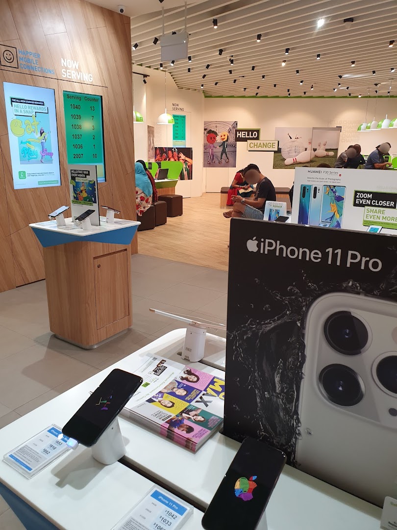 Interior view of StarHub Westgate, showcasing mobile phones, service counters, and customers browsing.