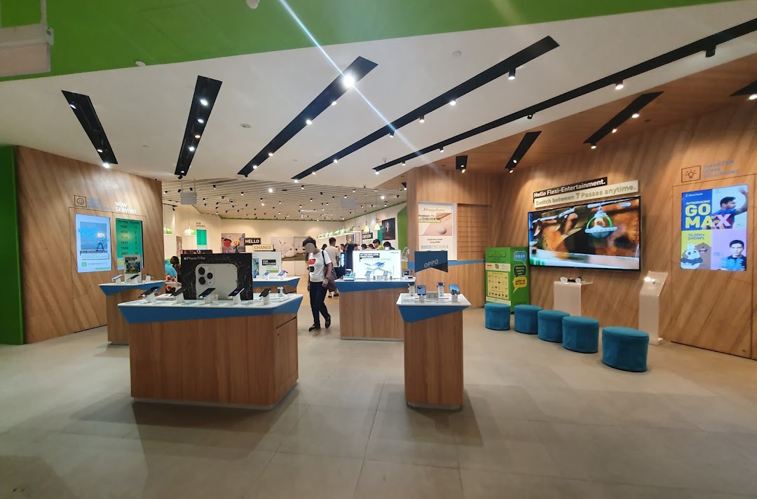 Interior view of StarHub Westgate, showcasing mobile phones on display tables and large promotional screens.