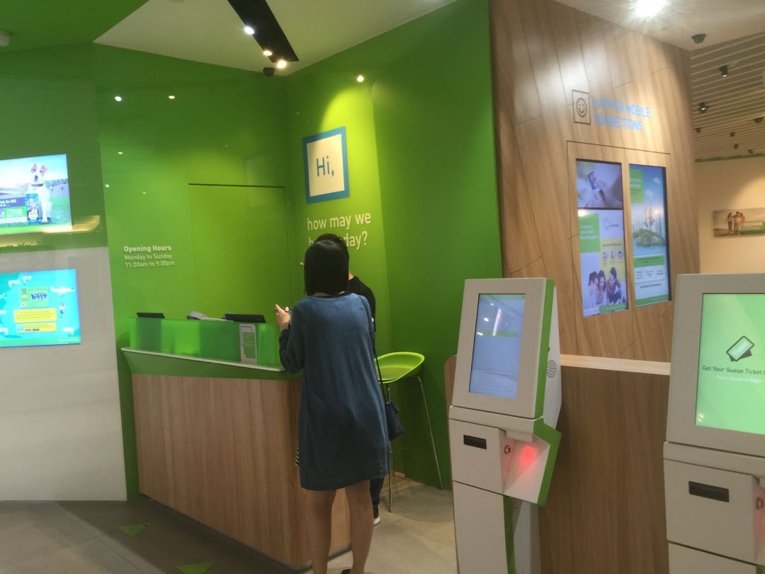 Interior view of StarHub Westgate featuring a customer service counter, self-service kiosks, and vibrant green branding.