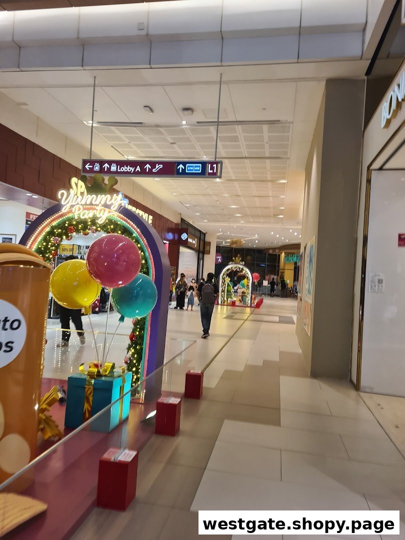 A bustling mall corridor adorned with festive 'SP Yummy Party' decorations, featuring balloons and gift boxes.
