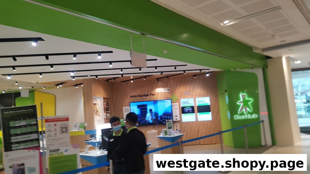 Interior view of StarHub Westgate, showcasing product displays, a large screen, and staff assisting customers.