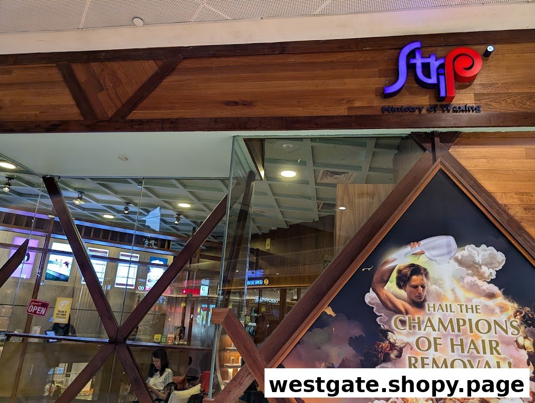 The shop front of Strip Co-Ed Westgate, a waxing salon, featuring its logo and promotional poster.