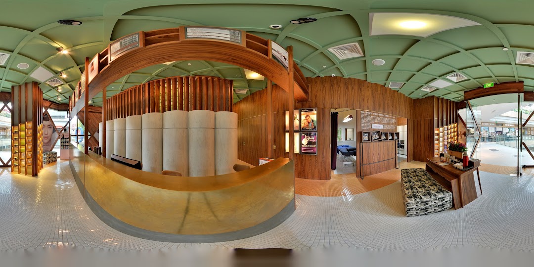 A panoramic view of Strip Co-Ed Westgate's modern interior, featuring a golden reception desk and treatment rooms.