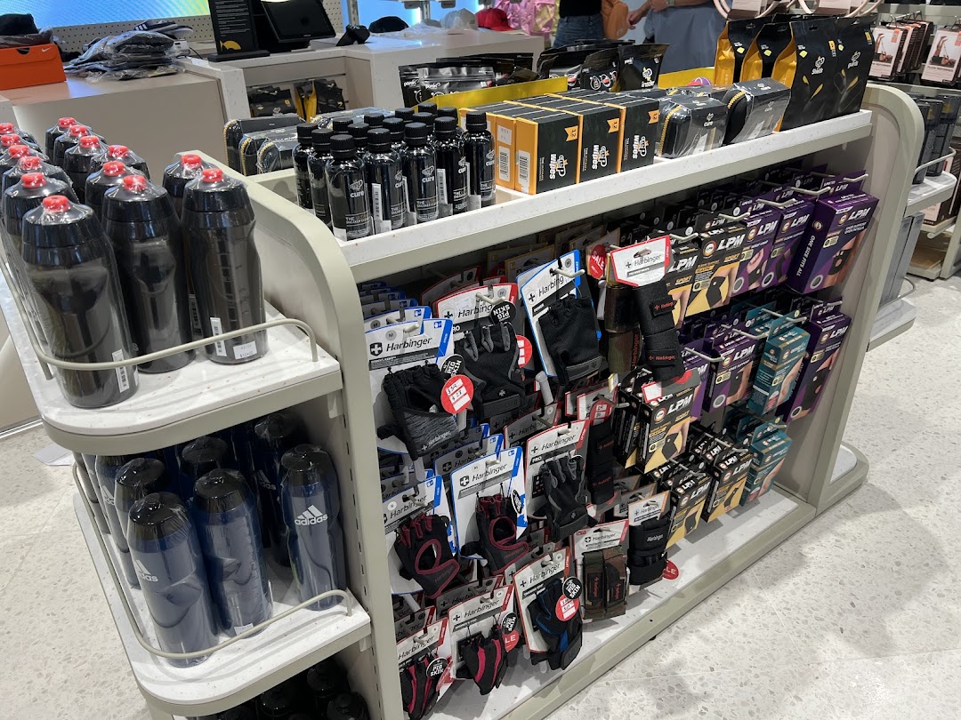 A retail display shelf showcasing various sports accessories, including water bottles, fitness gloves, and support gear.
