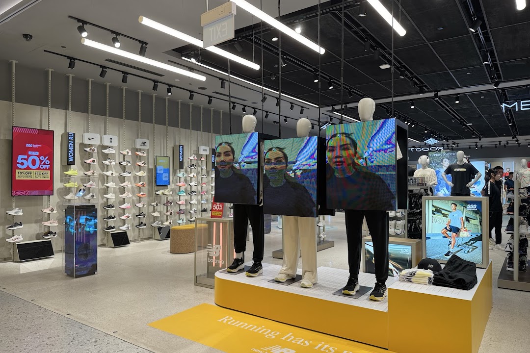 Interior view of Sun & Sand Sports, showcasing athletic footwear, apparel, and digital displays.