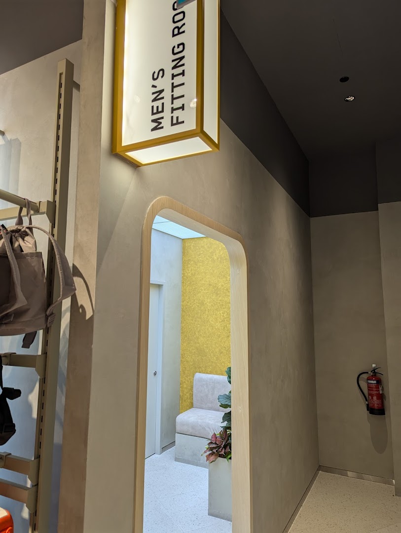 Interior view of Sun Sand Sports, highlighting the men's fitting room entrance with a clear sign.